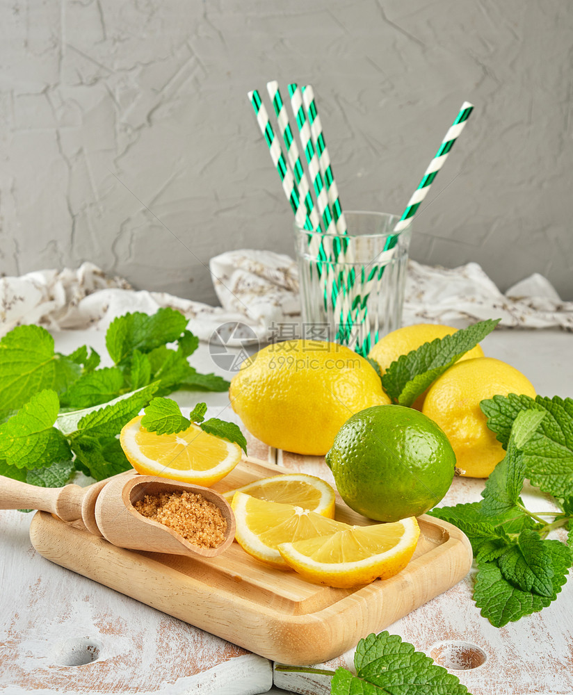 成熟的黄色全柠檬和棕糖白木板上一串新鲜薄荷柠檬汁的原料图片