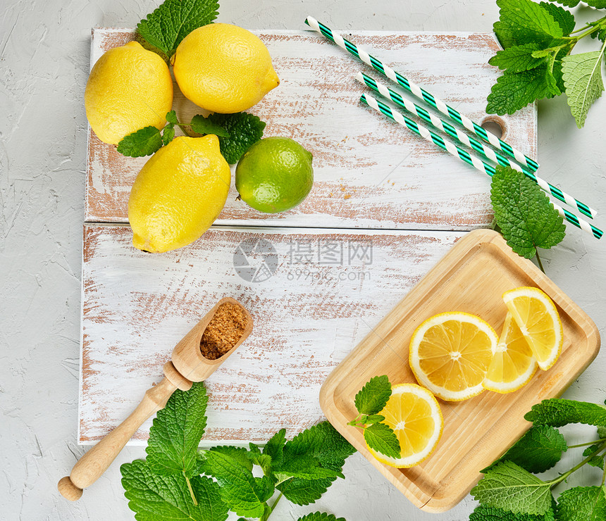 成熟的黄色全柠檬和棕糖白木板上一串新鲜薄荷柠檬汁的原料顶层风景图片