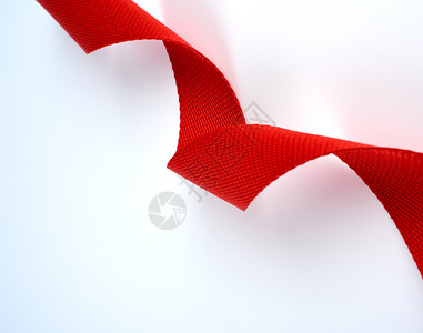 扭曲的红色纺织品带白背景上粗纤维关闭图片