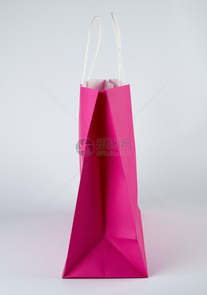 粉红色纸袋和白背景的手柄关上图片