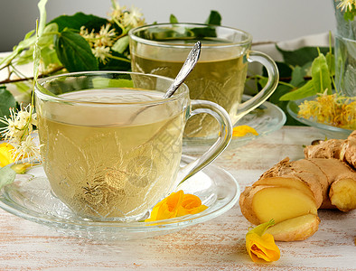 用茶杯姜汁的和白木板上叶子的茶杯图片