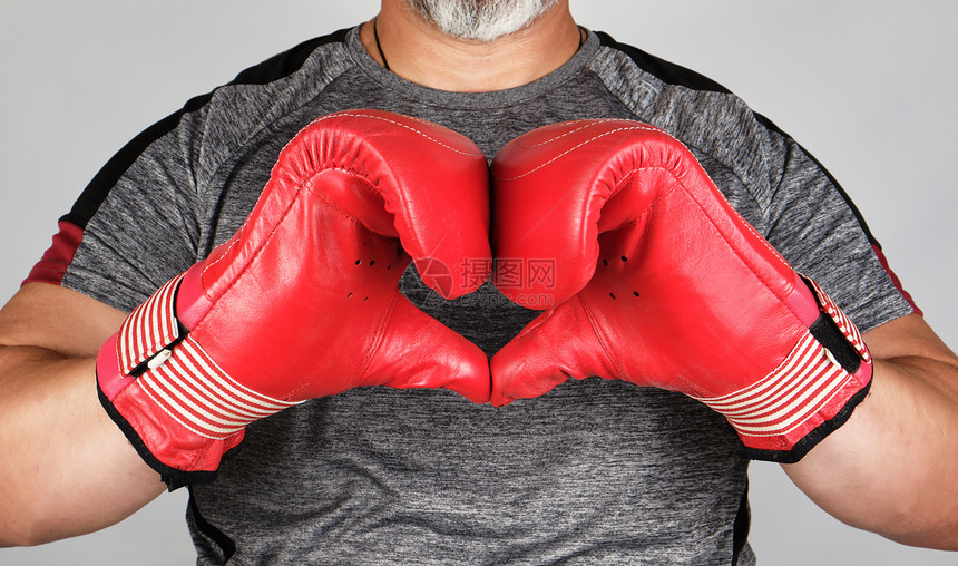 红色拳击运动员穿红色拳击的皮手套举心脏符号白底图片