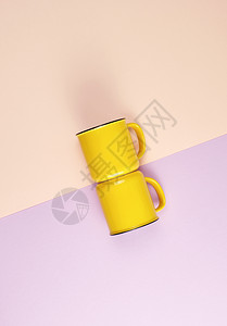 两个黄色陶瓷杯手柄在抽象的壁画背景上平铺图片