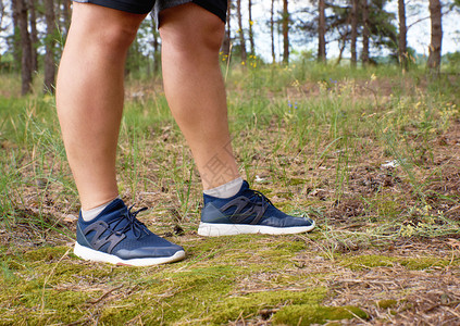 夏日在森林中央穿蓝鞋的运动员腿男子员的腿蓝鞋运动员在森林中间图片