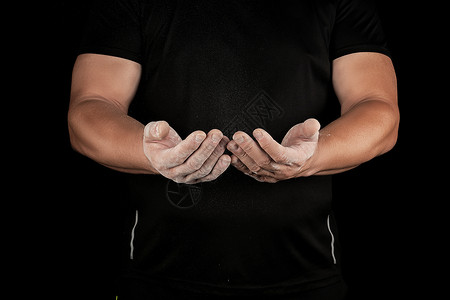 男成年运动员在体育赛事前用镁粉擦白黑色背景图片