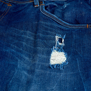 蓝色牛仔裤布的碎片一个洞完整的框架关闭图片