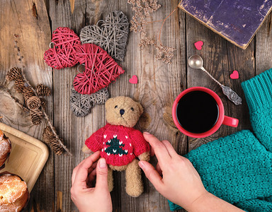 红茶杯黑咖啡和一只小泰迪熊红色毛衣灰木头背景图片