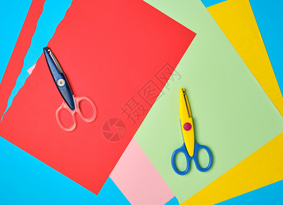 一对塑料剪刀和彩色纸用于切割数字应用和剪贴图片