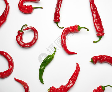 许多胡椒热辣全红果和白色背景的一片绿区别和歧视的概念图片