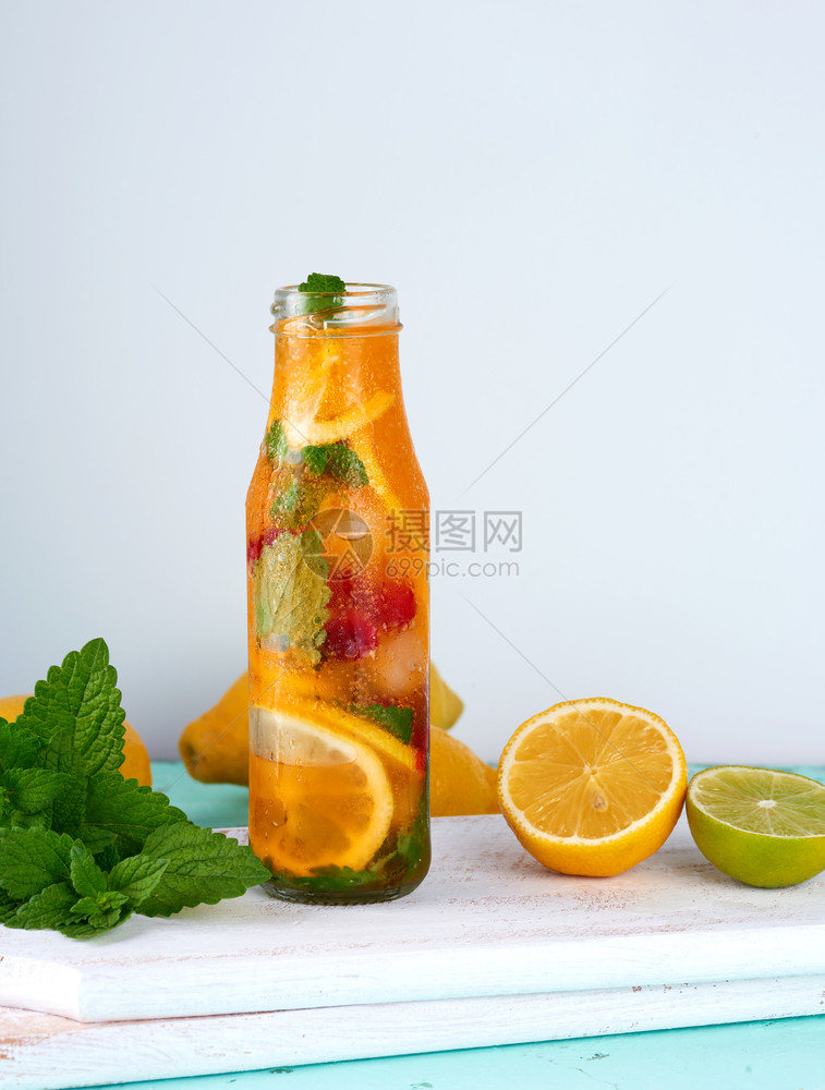 柠檬汁加红莓薄荷叶玻璃瓶中的石灰旁边是鸡尾酒的配料图片