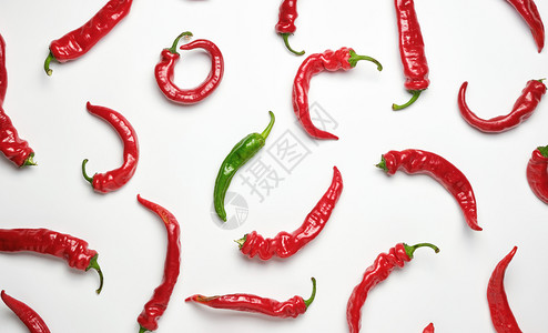 许多胡椒热辣全红果和白色背景的一片绿区别和歧视的概念图片