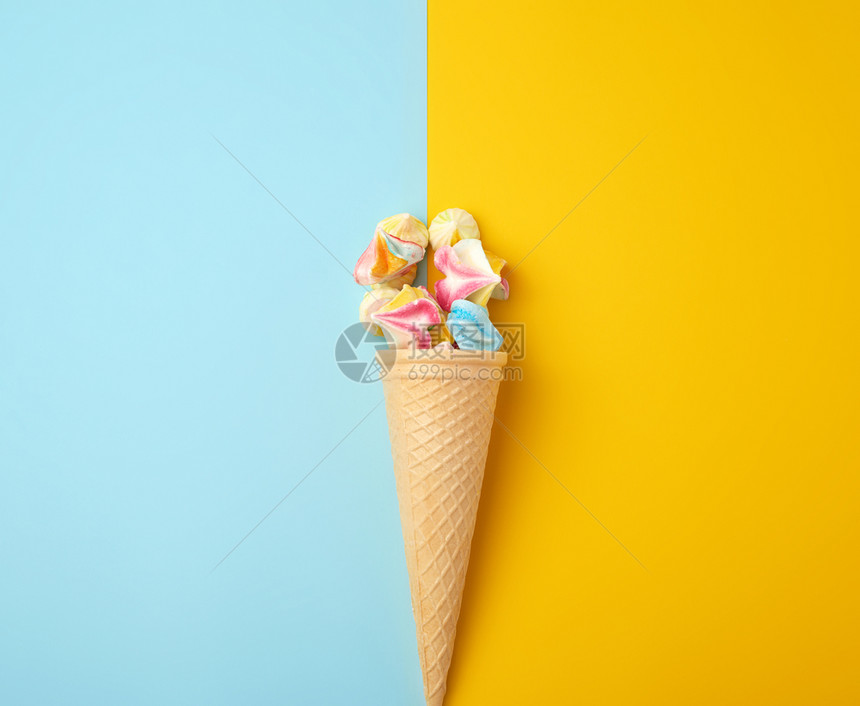 蓝色黄背景的华夫饼杯中多颜色的烤蛋白图片