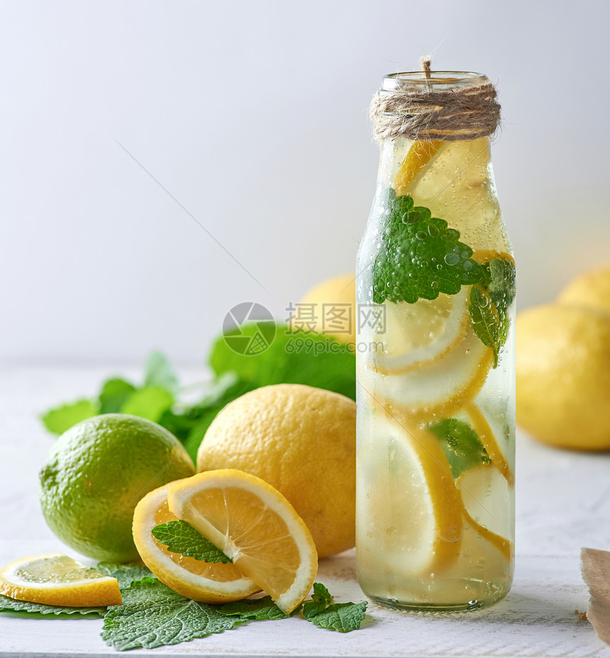 柠檬汁加薄荷叶玻璃瓶中的石灰与鸡尾酒的原料相邻图片