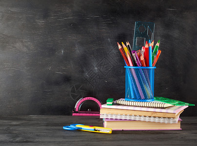 笔记本蓝色玻璃和多木铅笔标尺空白黑粉笔板背景上的橡皮笔回到学校概念图片