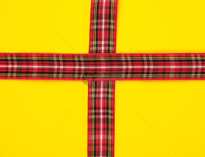 在黄背景节日的上用盒式装饰的红色丝带图片