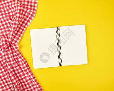 红色纸巾和开放笔记本黄色背景顶视平面图片