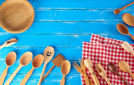 在蓝色背景复制空间厨房背景上有许多不同的木制勺子叉和空板图片