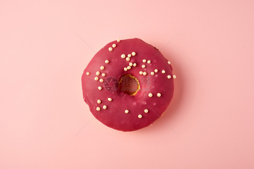 红色圆甜圈白喷洒在粉红色背景上最视图图片