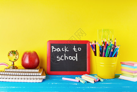 粉笔和粉笔盒黑色粉笔架和学校用品蓝背景概念返回学校背景