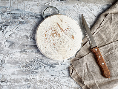空圆木板刀和灰色厨房毛巾放在水泥背景顶视图上图片