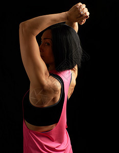黑头发的年轻运动女孩转过身背部肌肉和手臂低键图片