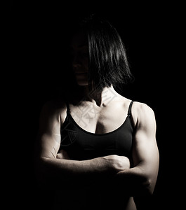 一个美丽的运动女孩肖像黑色头发她的手臂交叉在她的胸前黑白图片