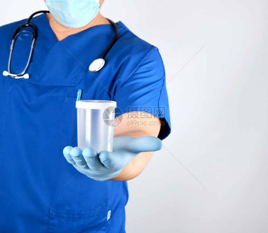 穿蓝色制服和乳胶手套的医生携带一个空塑料容器用于抽取清底白色的尿液样本图片