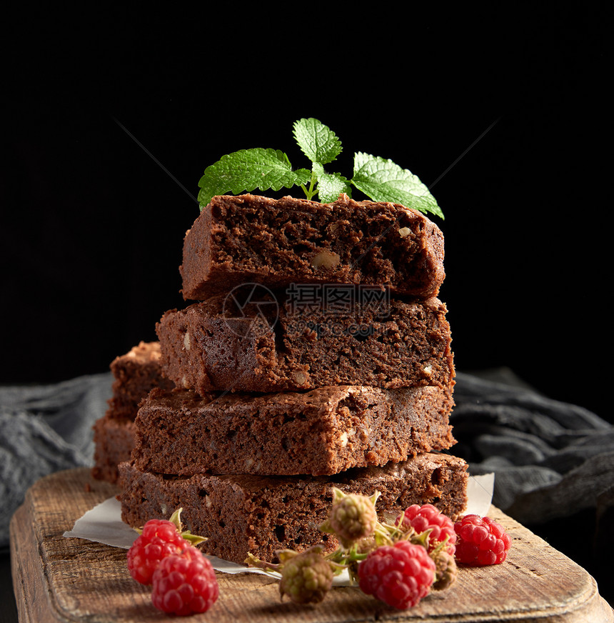 黑底棕色木切板上的巧克力蛋糕图片