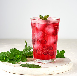 夏季清新饮料用红莓浆果和冰块在一木板上的玻璃杯中白底背景图片