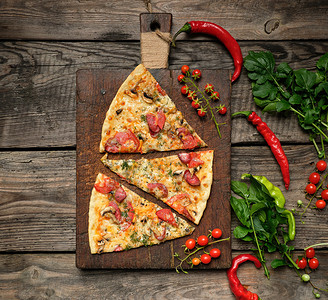 用熏香肠蘑菇西红柿奶酪和薄饼烤圆披萨在棕色木板上切片食品关闭图片