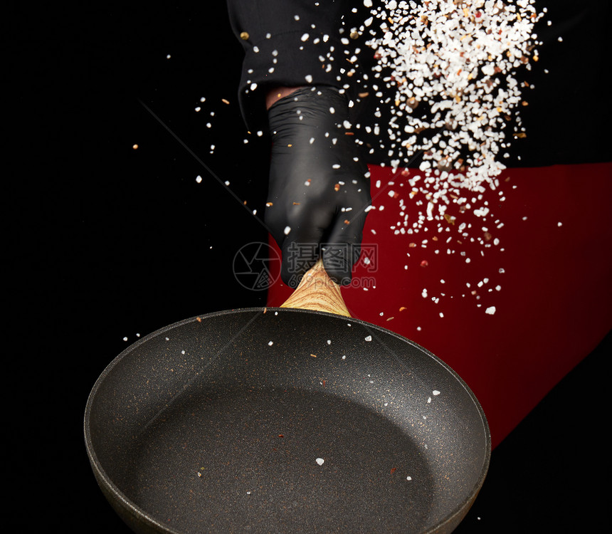 厨师拿着圆锅把香料和白盐混合起来低键图片