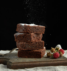 堆成的方面包巧克力蛋糕片上面洒满白糖小粒子飞下来低键图片