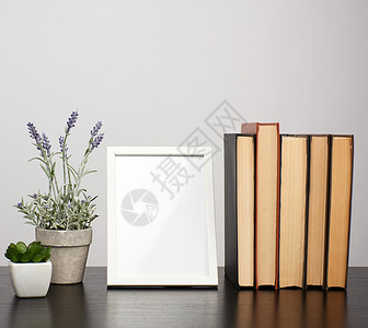 黑照片框素材空白照片框堆叠的书籍和黑桌工作场所的熏衣草锅背景