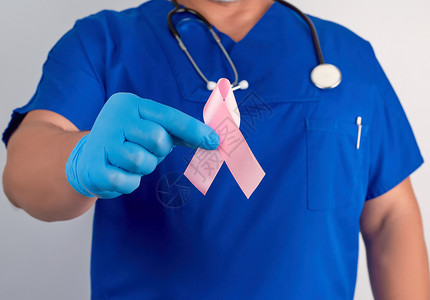 防治碘缺乏病日蓝制服医生和无菌乳胶手套的蓝制服医生和无菌乳胶手套佩带粉红色丝这是10月2日防治乳腺癌斗争的象征背景