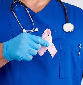 蓝制服医生和无菌乳胶手套戴着粉红色丝带图片