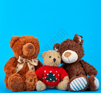 三只泰迪熊蓝背景友谊概念关闭图片