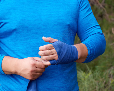 运动员在训练前站蓝色纺织弹绷带上包着他的手苏尼暑假户外图片