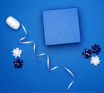 纸板礼品箱弓深蓝色背景包装带顶视图趋势颜色图片