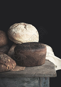 各种烤面包卷黑麦在木表古老的对立关闭图片