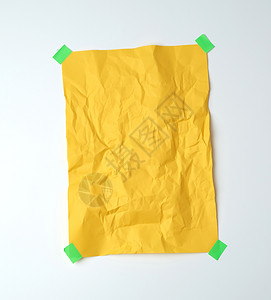 白色背景文字位置上用绿色粘纸贴在白色背景上的空黄折叠纸图片