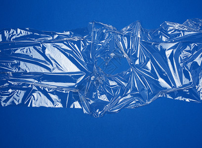 为包装产品在蓝底全框架闭合的包装产品制作透明拉伸塑料薄膜的纹理图片