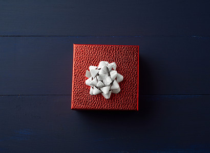 带有金丝祝贺和礼物概念顶视蓝木背景的红色方盒背景