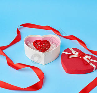 红心形礼物盒蓝背景喜庆上有一个弓情人节礼物图片