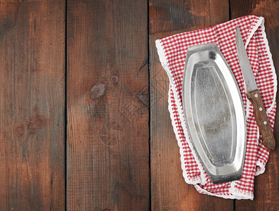 白色红格式厨房毛巾铁板和棕色木背景野餐复制空间上的尖利旧刀图片