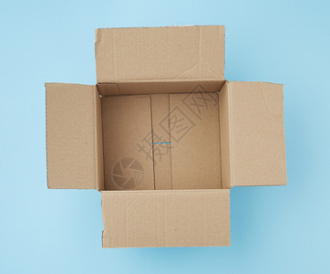 用于在蓝色背景顶视图上包装和运物品的平方空纸板棕色框图片
