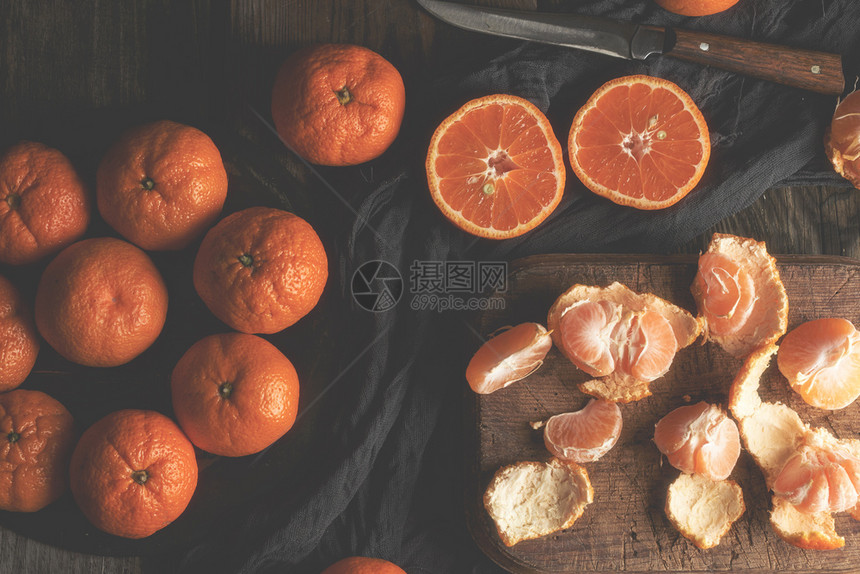 成熟的圆橘子切成两半的老旧菜板健康素食柑橘水果图片