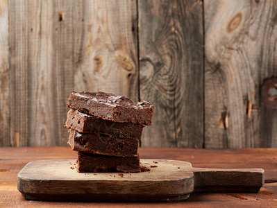 木质表面配有胡桃的巧克力蛋糕木质食品巧克力糕点甜食自制点木餐桌图片