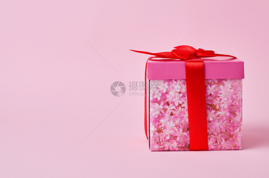 粉红色背景的弓捆绑着粉色的盒式纸板粉红色盒式箱纸板图片