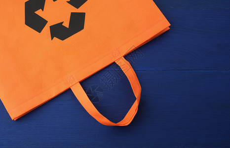 蓝木本底的可再使用橙色刺鼻袋塑料废物减少概念图片