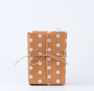 装在包着棕色克拉夫纸和白背景上绑绳子的盒装礼物中Festive概念复制空间图片
